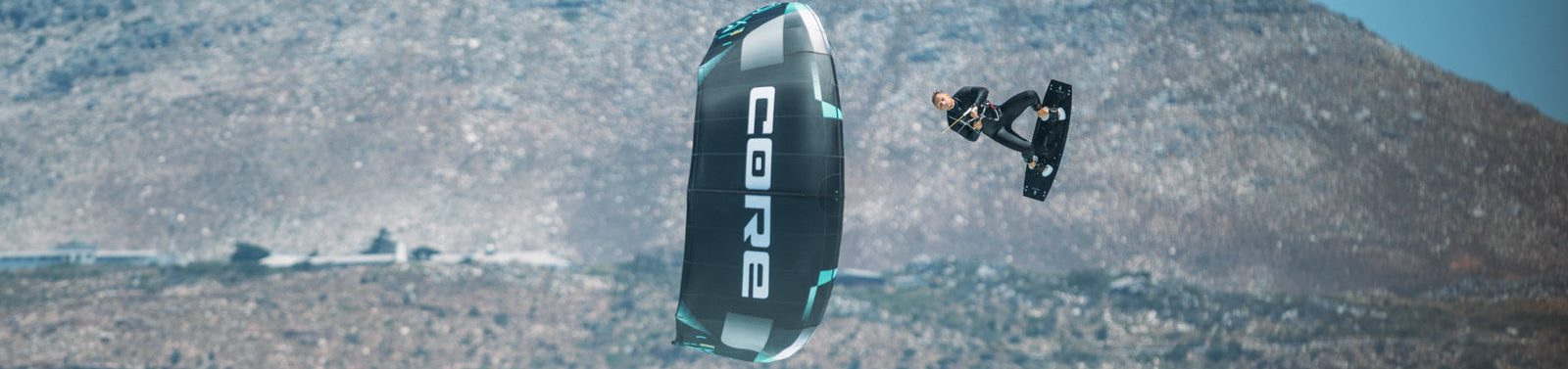 Person kiteboarding with a Core kite against a mountainous landscape